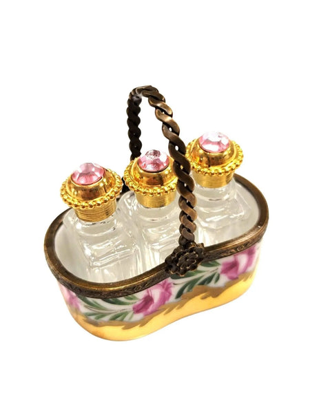 Vintage Limoges luxury French perfume bottles set with pink jeweled gold caps in decorative floral carrier