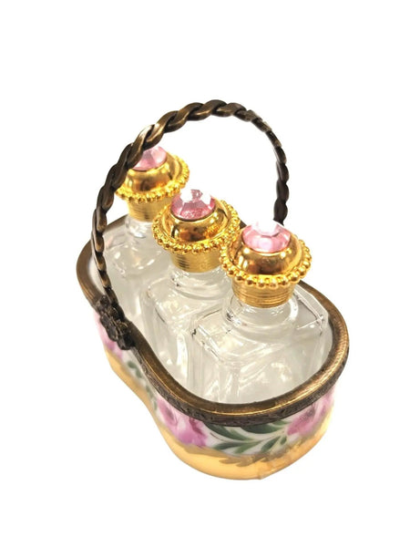 Vintage Limoges luxury French perfume bottles with gold accents and pink floral design in decorative holder