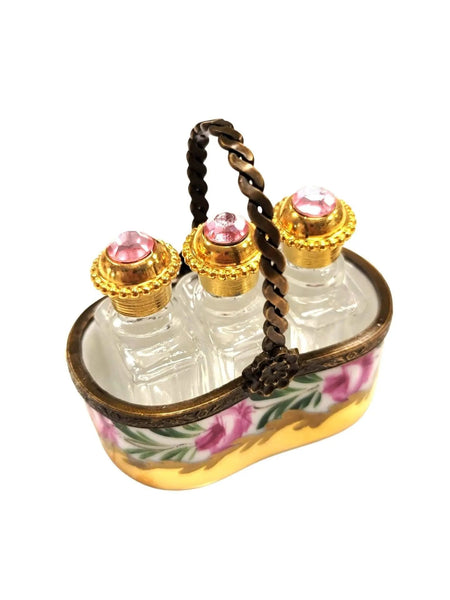 Vintage Limoges luxury French perfume bottles set with pink gemstone tops in decorative floral carrier